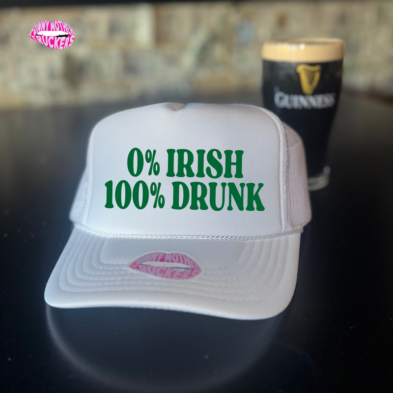 White cap with '0% Irish 100% Drunk' text, pink lips graphic, and Guinness beer in the background.