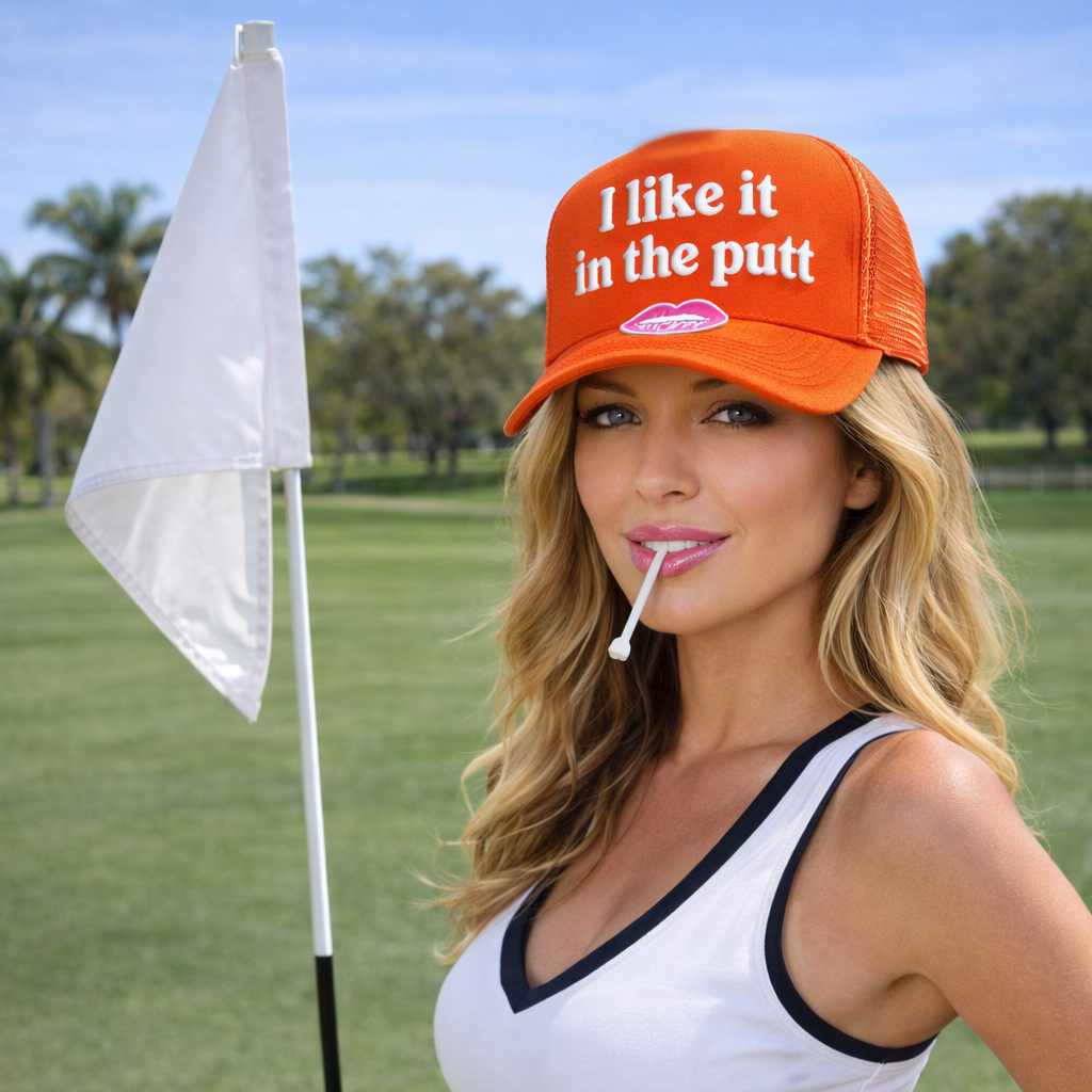 Woman wearing an orange cap with text on a golf course