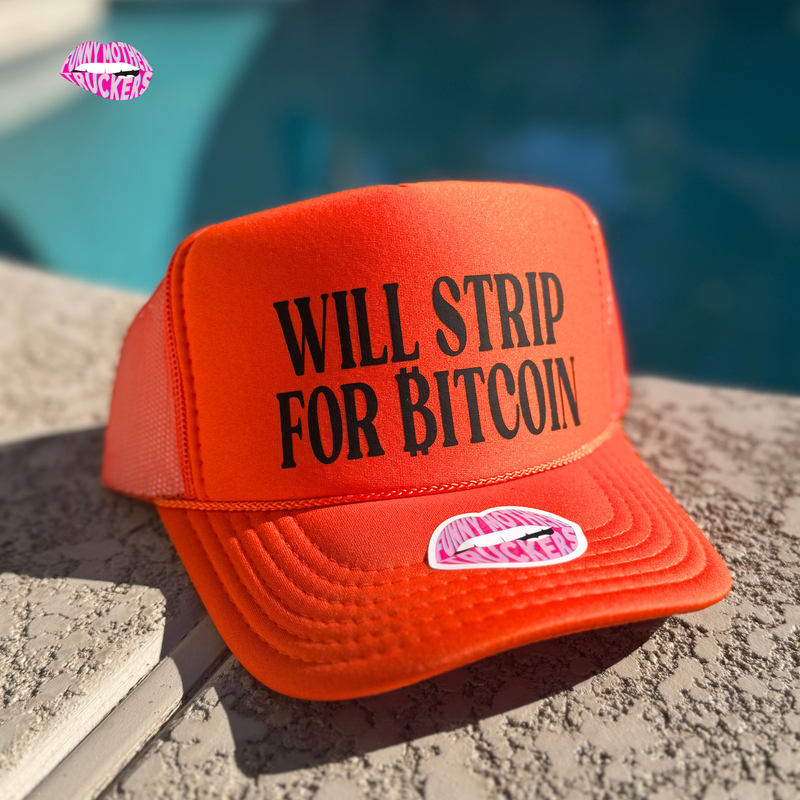 Red cap with 'WILL STRIP FOR BITCOIN' text on a concrete surface with a blurred blue background.